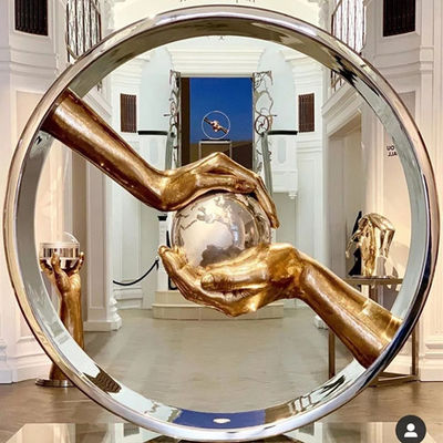 A mão lustrou o espelho de aço inoxidável guardando as esculturas da terra